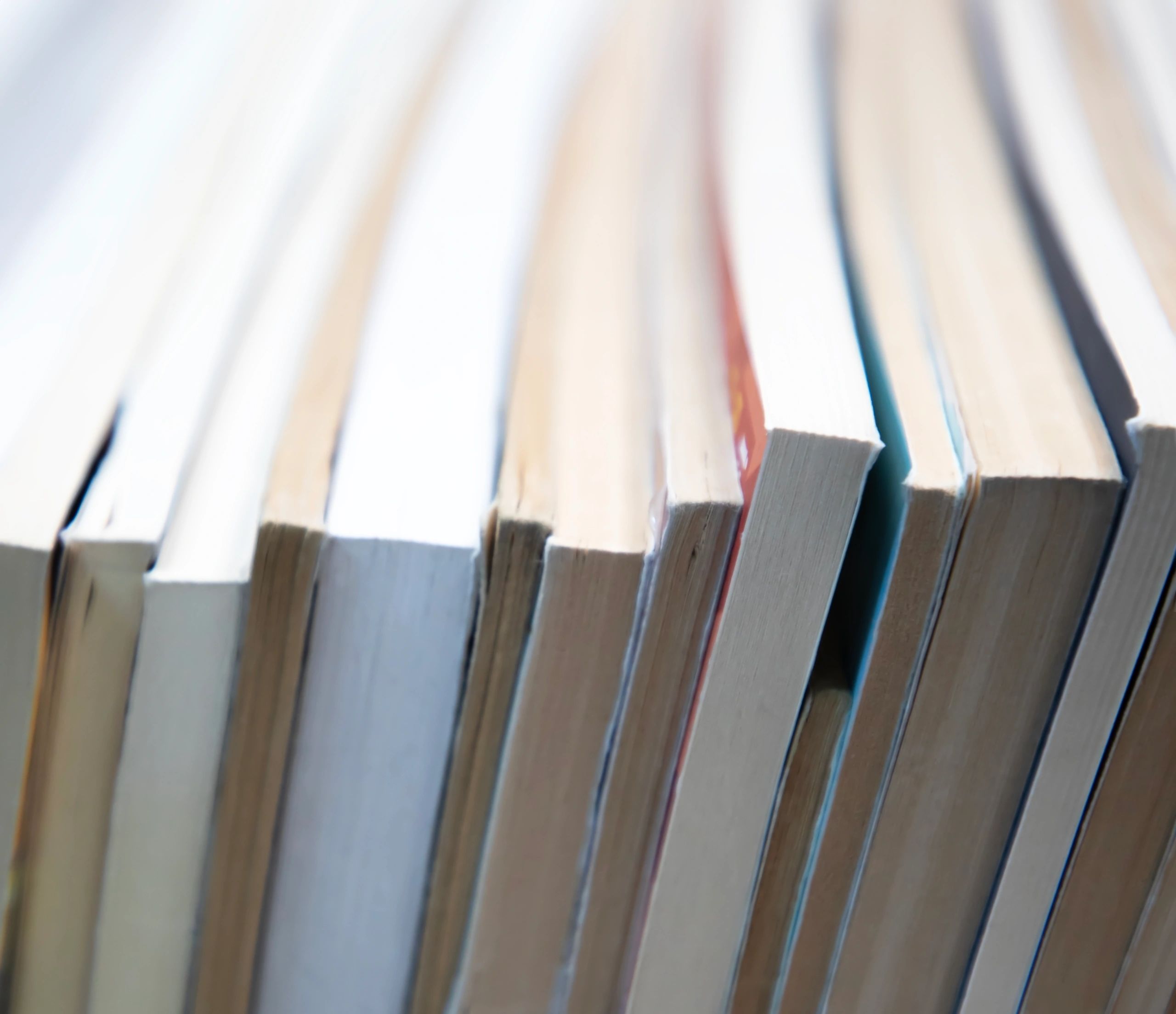 Soft bookshelf-style image with stacked books and neutral tones